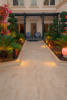 "Luxury villa backyard with elegant landscaping, flowering plants, topiary trees, and ambient lighting"
