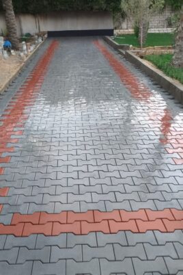 Luxury interlock pathway with red and gray tiles in landscaped garden
