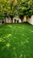 Villa landscaping Dubai with artificial grass, shaded trees, and decorative lighting