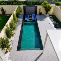 Villa pool construction Dubai with modern house design, pergola, and clear water pool